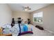 Cozy bedroom with a ceiling fan, a desk, and a window overlooking the neighborhood at 4915 Juniper Grove Sw Ct, Concord, NC 28027
