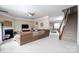 Open-concept living room featuring a fireplace, plush seating, and staircase at 4915 Juniper Grove Sw Ct, Concord, NC 28027