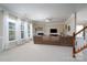 Open concept living room featuring a fireplace, plush seating, large windows, and staircase at 4915 Juniper Grove Sw Ct, Concord, NC 28027