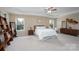 Spacious main bedroom featuring a tray ceiling, a ceiling fan, two windows, and neutral decor at 4915 Juniper Grove Sw Ct, Concord, NC 28027