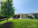 Enjoy an outdoor living space with a cozy fire pit, covered patio, and beautifully maintained lawn for relaxation and entertaining at 5003 Looking Glass Trl, Denver, NC 28037