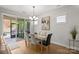 Bright dining room featuring a glass table, stylish chandelier, and sliding doors to a screened porch at 5003 Looking Glass Trl, Denver, NC 28037