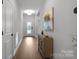 Inviting foyer with wood flooring, a decorative front door, and a stylish accent cabinet at 5003 Looking Glass Trl, Denver, NC 28037