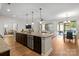 Open kitchen with granite countertops, stainless steel appliances, dark cabinets, hardwood floors, and large island at 5003 Looking Glass Trl, Denver, NC 28037