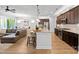 Open concept kitchen view to living room featuring granite island and stainless steel appliances and hardwood floors at 5003 Looking Glass Trl, Denver, NC 28037