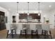 Beautiful kitchen with granite countertop island, dark wood cabinets, pendant lights, and stainless steel appliances at 5003 Looking Glass Trl, Denver, NC 28037