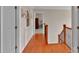 Hallway features hardwood flooring, wooden railings, and natural light. It creates a warm and inviting path throughout the home at 508 Whitehead Ct # 328, Fort Mill, SC 29708