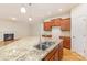 Granite countertop kitchen island with a stainless steel sink and wood cabinets at 527 Livingston Dr, Lancaster, SC 29720