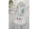 Charming powder room with pedestal sink, oval mirror, and decorative shelving for added storage at 5324 Somerset Hill Ln, Charlotte, NC 28269