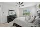 This bedroom features a dark dresser, ceiling fan, large window, and stylish decorations at 5324 Somerset Hill Ln, Charlotte, NC 28269