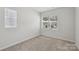 Bedroom with a large window and neutral colored walls and carpeting at 5324 Somerset Hill Ln, Charlotte, NC 28269