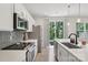 The open kitchen features stainless steel appliances, gray backsplash, and a sliding glass door to the backyard at 5324 Somerset Hill Ln, Charlotte, NC 28269