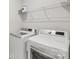 Bright laundry room featuring modern washer and dryer units with overhead shelving at 5324 Somerset Hill Ln, Charlotte, NC 28269