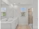 Bathroom with double vanity, large mirror, and view to glass-enclosed shower at 5332 Orchid Bloom Dr, Indian Land, SC 29707