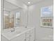 Bathroom with double vanity sinks, large mirror, window, and glass-enclosed shower at 5332 Orchid Bloom Dr, Indian Land, SC 29707