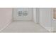 This bedroom features neutral walls and carpet, and a window letting in natural light at 5332 Orchid Bloom Dr, Indian Land, SC 29707