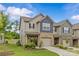 A beautiful two-story townhome with a well-kept lawn and neutral siding, complemented by a brick-accented garage at 5332 Orchid Bloom Dr, Indian Land, SC 29707