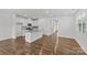 Bright and airy kitchen area featuring an island, sleek white cabinetry, and hardwood floors throughout the space at 5332 Orchid Bloom Dr, Indian Land, SC 29707