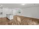 A bright living space features natural light, wood-look floors, and a partially visible kitchen island at 5332 Orchid Bloom Dr, Indian Land, SC 29707