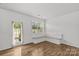 A naturally lit living area has wood floors, an exit door, and a built-in bench by the window at 5332 Orchid Bloom Dr, Indian Land, SC 29707