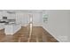 A spacious living room with natural lighting, wood-look floors, and an open kitchen area at 5332 Orchid Bloom Dr, Indian Land, SC 29707
