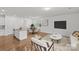 A combined living and dining space features wood floors, neutral decor, and a kitchen island at 5332 Orchid Bloom Dr, Indian Land, SC 29707