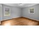 Bedroom featuring hardwood floors and natural light from two windows at 5918 Barrington Dr, Charlotte, NC 28215