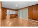 Living room with hardwood floors, wood paneling and view into the kitchen at 5918 Barrington Dr, Charlotte, NC 28215