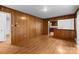 Living room with hardwood floors, wood paneling and view into the kitchen at 5918 Barrington Dr, Charlotte, NC 28215