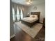 Cozy bedroom with large window, ceiling fan, and hardwood floors at 5929 Waterelm Ln, Charlotte, NC 28269