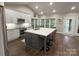 Spacious open kitchen with stainless appliances, white cabinets, large island, and hardwood floors at 5929 Waterelm Ln, Charlotte, NC 28269