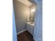 Powder room featuring dark flooring, gray walls, a white vanity, and modern lighting at 5929 Waterelm Ln, Charlotte, NC 28269