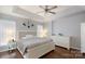 Spacious bedroom showcasing tray ceilings, a ceiling fan, natural light from windows, and sleek white furniture at 609 Atherton Way, Rock Hill, SC 29730