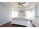 Relaxing bedroom with a tray ceiling, ceiling fan, large windows, and a comfortable bed with stylish decor at 609 Atherton Way, Rock Hill, SC 29730