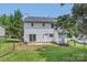 Two story home with white siding, small back patio, and chain link fence on a grassy lot at 6221 Round Hill Rd, Charlotte, NC 28211