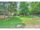 Large, grassy backyard with trees and fencing offers plenty of space for outdoor enjoyment at 6221 Round Hill Rd, Charlotte, NC 28211