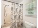 Bathroom with patterned shower curtain, white trim, and bright natural light at 6221 Round Hill Rd, Charlotte, NC 28211