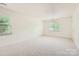 This bedroom has large windows with blinds and light-colored carpeted floors at 6221 Round Hill Rd, Charlotte, NC 28211