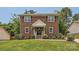 Charming two-story red brick home featuring a well-manicured lawn and inviting front porch, creating a warm and welcoming curb appeal at 6221 Round Hill Rd, Charlotte, NC 28211