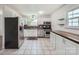 Bright kitchen with white cabinets, stainless steel appliances, and tiled flooring, offering a clean and modern space at 6221 Round Hill Rd, Charlotte, NC 28211