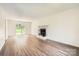 Spacious living room featuring modern wood-look flooring, a fireplace, and sliding glass doors to the exterior at 6221 Round Hill Rd, Charlotte, NC 28211