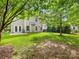 Lush backyard with a grassy lawn, mature trees, and a patio with French doors at 6619 Hermsley Rd, Charlotte, NC 28278