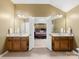 En suite bathroom showcasing dual vanities, mirrors, and a glimpse into the main bedroom at 6619 Hermsley Rd, Charlotte, NC 28278