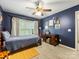 Bedroom with blue walls, carpeted floors, a dark wood bed frame and a ceiling fan at 6619 Hermsley Rd, Charlotte, NC 28278