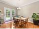 Cozy dining area with hardwood floors, a chandelier, and direct access to the backyard through French doors at 6619 Hermsley Rd, Charlotte, NC 28278