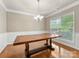 Bright dining room featuring hardwood floors, a modern chandelier, and a large window overlooking the yard at 6619 Hermsley Rd, Charlotte, NC 28278