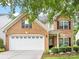 Charming two-story brick home featuring a two-car garage, manicured lawn, and beautifully landscaped front yard at 6619 Hermsley Rd, Charlotte, NC 28278
