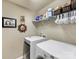 Functional laundry room with full-size washer and dryer, utility shelving and decor at 6619 Hermsley Rd, Charlotte, NC 28278