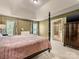 Bedroom with neutral walls, a ceiling fan, a four-poster bed, and access to the bathroom at 6619 Hermsley Rd, Charlotte, NC 28278