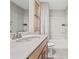 Bright bathroom featuring a large vanity with quartz countertop, bathtub with white tiling, and stylish decor at 7101 Short Stirrup Ln, Mint Hill, NC 28227